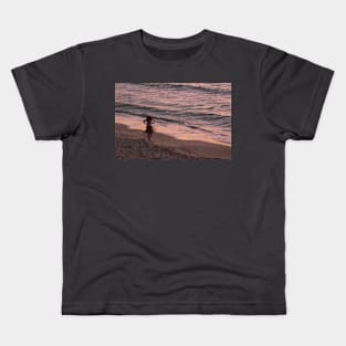 Girl on a beach, dusk Kids T-Shirt